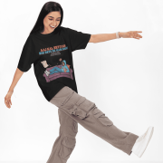 Black Modern Beti Oversized T-shirt – Zero Kaam Attitude Edition by PodLyft. A model in a playful pose wearing a black graphic tee with text that reads "Majal Hai Ghar Ka Koi Kaam Kare."